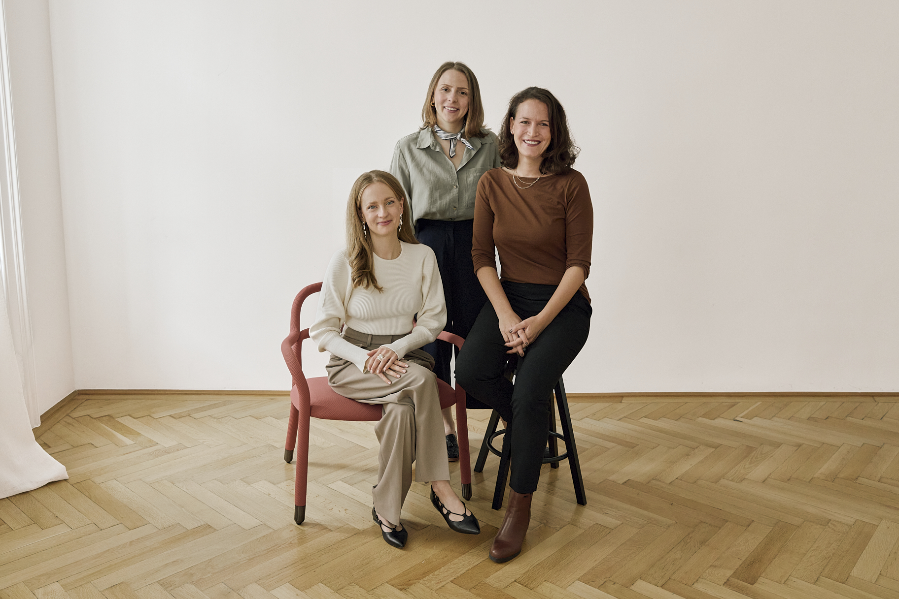 Three women from Glasswing Collective sitting together, representing their brand transformation agency.